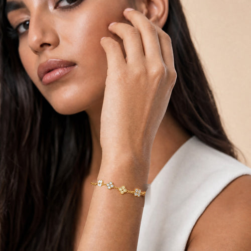 Bracelet CLOVER PURE porté au poignet — trèfles nacre blanche et zircons, or 18K, LOUSYĀ